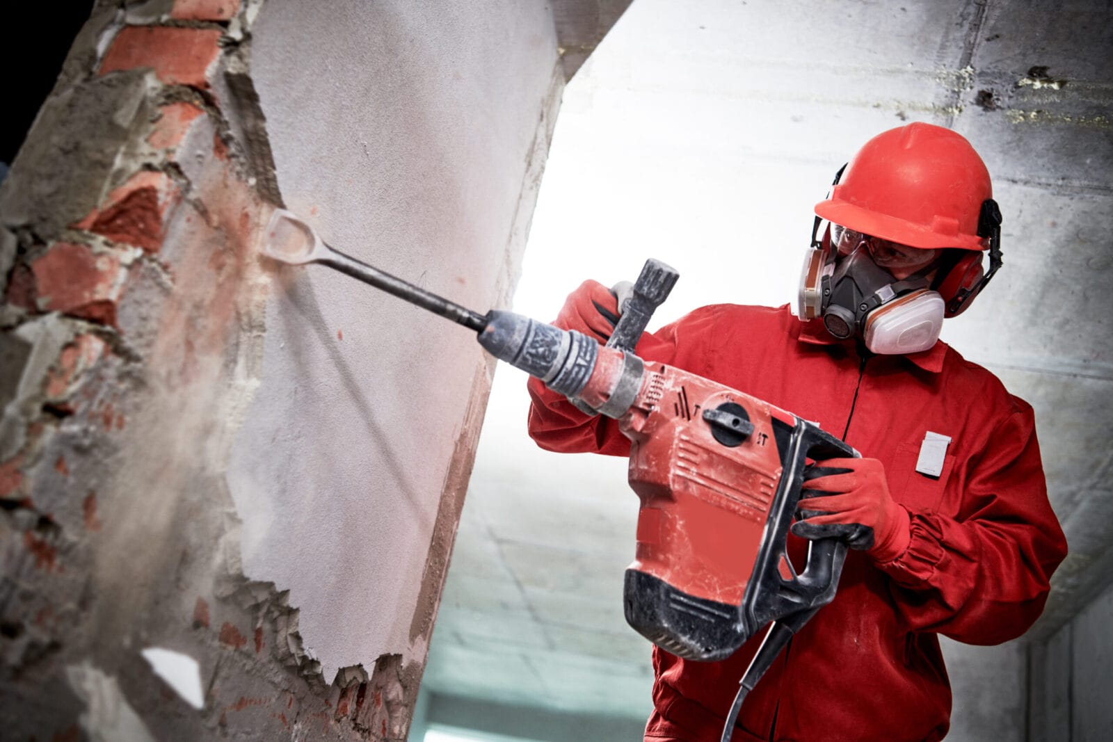 A construction worker using a hammer drill at home.