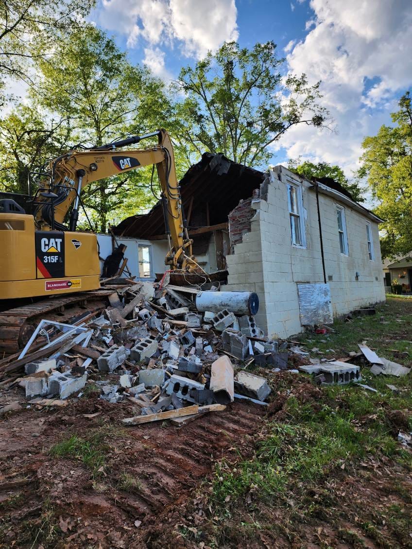 Excavator demolishing a house
